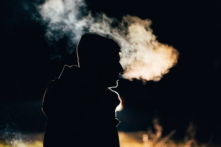 A self-controlled man exhaling smoke