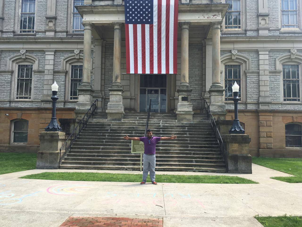 A Colombian traveler standing with arms spread in Washington, D.C.