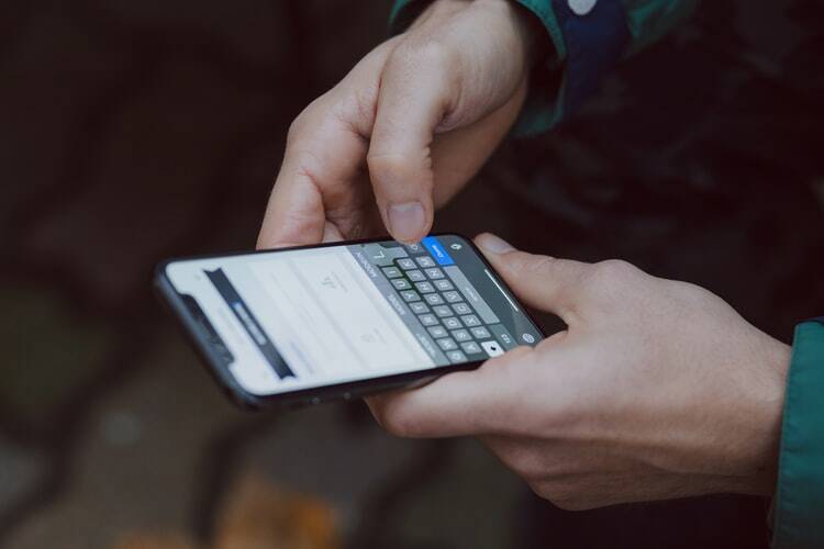 A man holding a smartphone emitting blue light