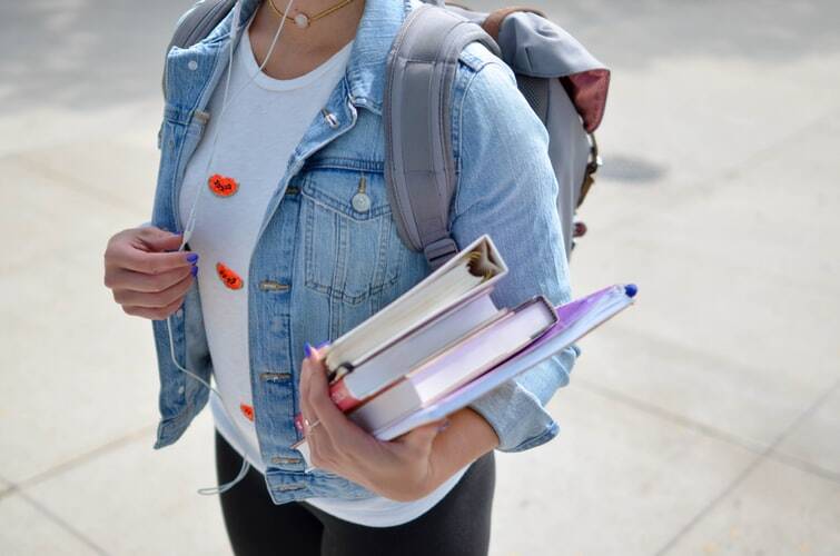 a female student with a perfect 4.0 grade point average ready to ace high school and college classes with her books and backpack 