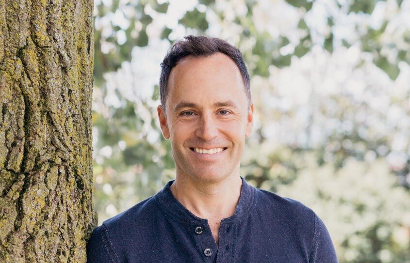 Meditation expert Jeff Warren standing by a tree