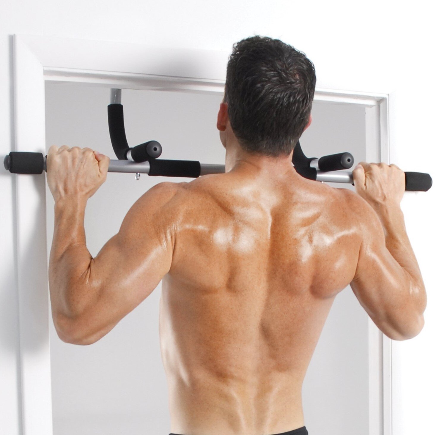 Man using iron gym workout bar to do pull-ups and push-ups