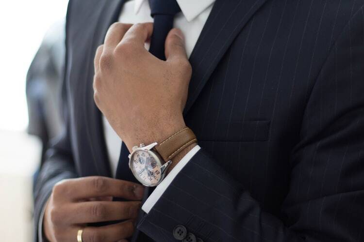 a confident man wearing a suit, tie, and watch